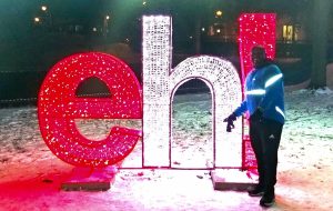 Runner pointing at a lighted eh! sign.