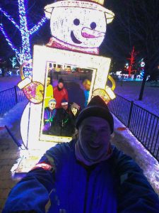 Runners pose inside a snowman frame.