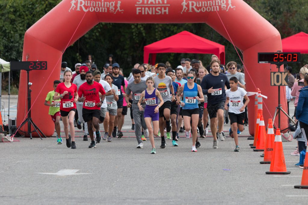 People running across the starting line at the 5 km Don Doan Dash.